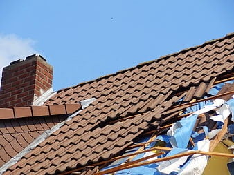 Damaged Roof Tiles and Exposed Structure After Storm