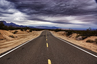 Straight Desert Highway Under Dramatic Stormy Sky