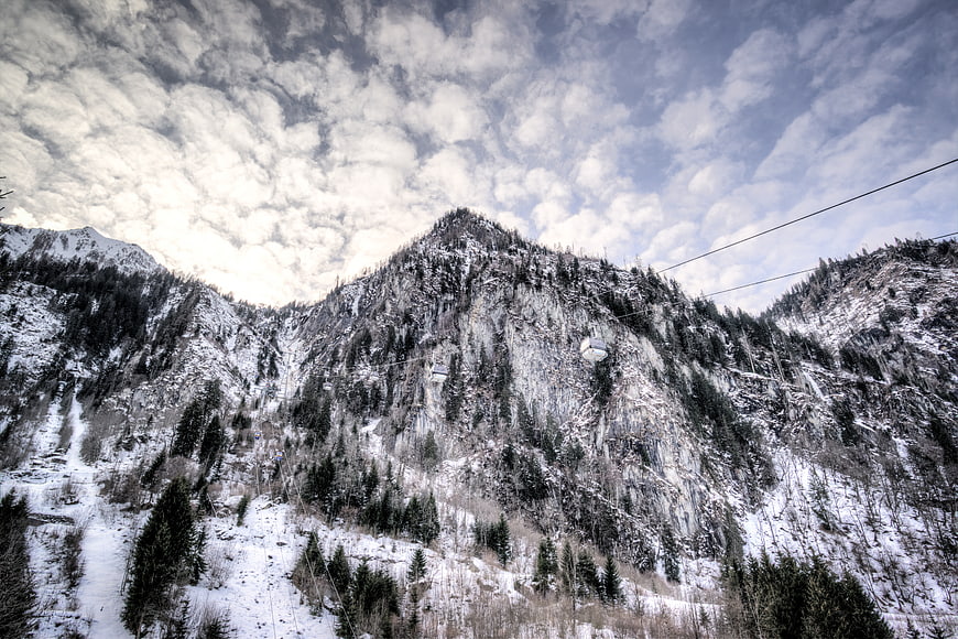 Snowy Mountain Landscape with Cable Car and Cloudy Sky