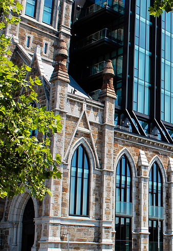 Gothic stone church facade with modern glass skyscraper background