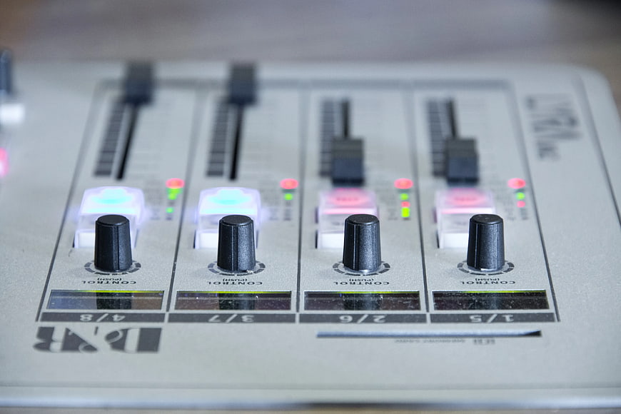 Close-up of DJ mixer control panel with knobs and sliders
