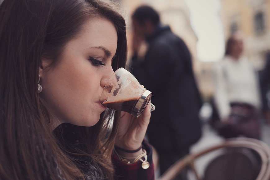 Woman Sipping Espresso at Outdoor Cafe