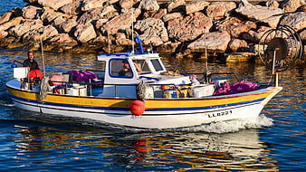 Traditional fishing boat arriving at harbor with fishermen