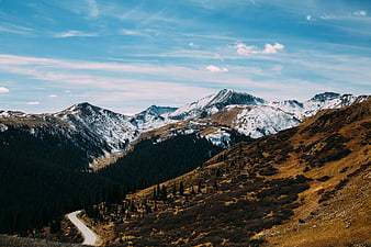 Winding Mountain Road Through Snowy Peaks and Forest
