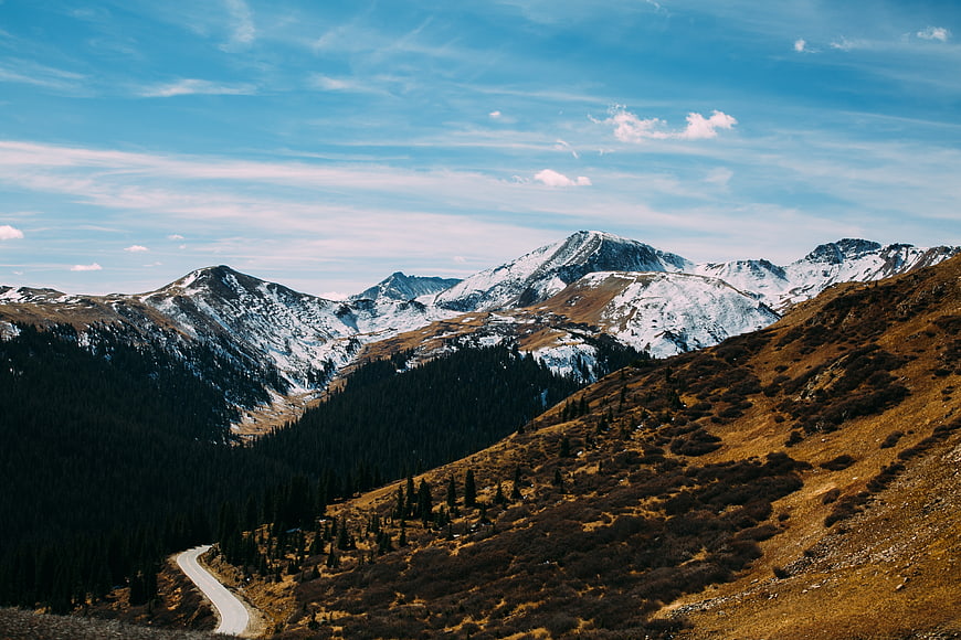 Winding Mountain Road Through Snowy Peaks and Forest