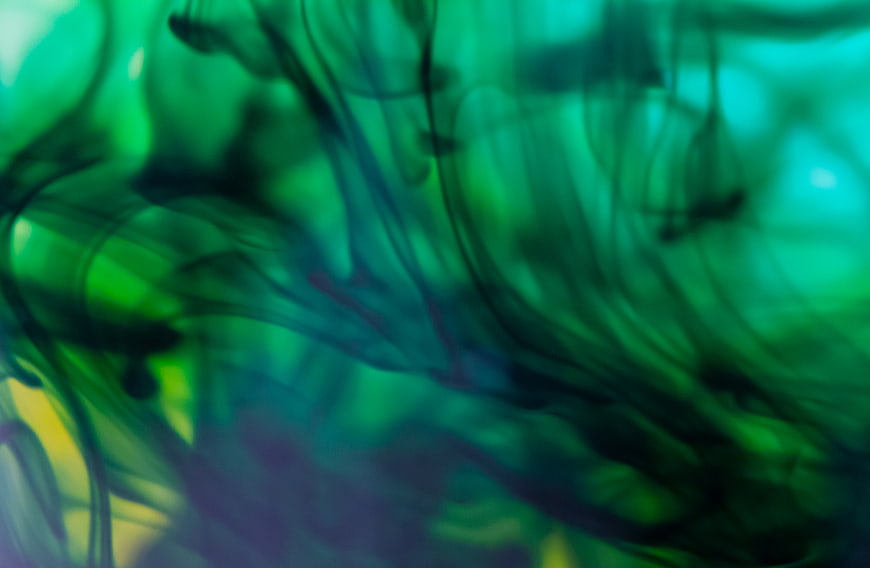 Abstract green ink swirls in water background