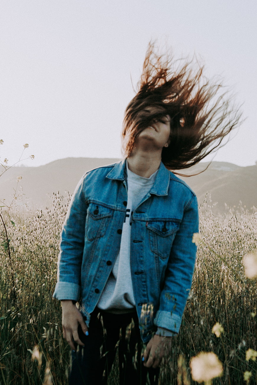 Woman with windblown hair in a field of tall grass