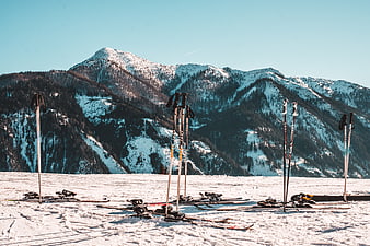 Ski poles and skis on snowy mountain slope
