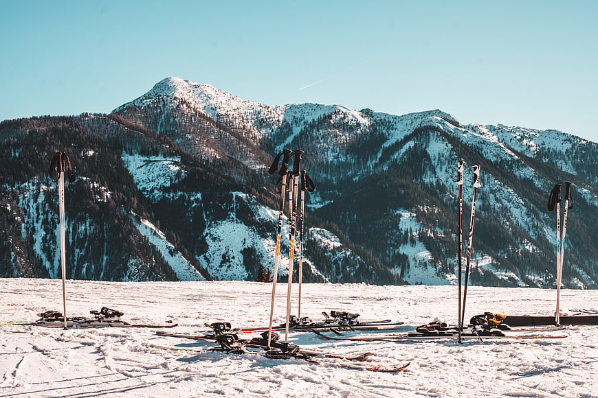 Ski poles and skis on snowy mountain slope