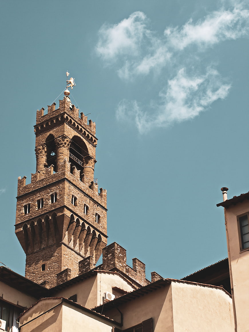 Low angle view of medieval stone tower against blue sky