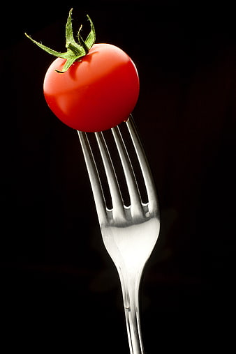 Fresh Red Cherry Tomato on Silver Fork Against Black Background