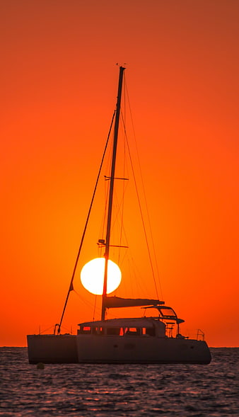 Catamaran Silhouette Against Vibrant Orange Sunset Sky