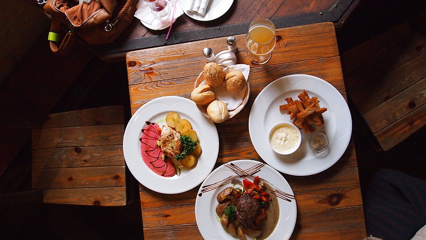 Overhead view of restaurant meal with steak, salmon, and fries
