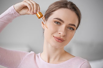Woman Applying Serum Dropper to Face