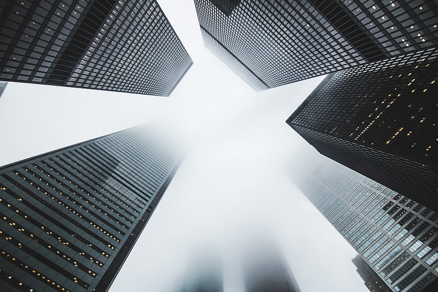 Low angle view of skyscrapers disappearing into thick fog
