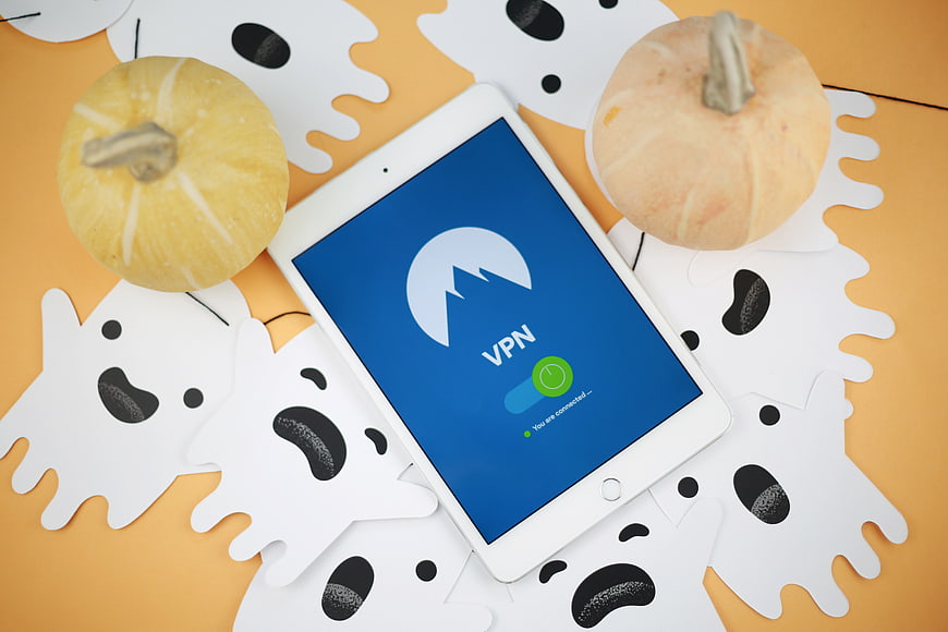 Tablet with VPN app surrounded by Halloween ghosts and pumpkins