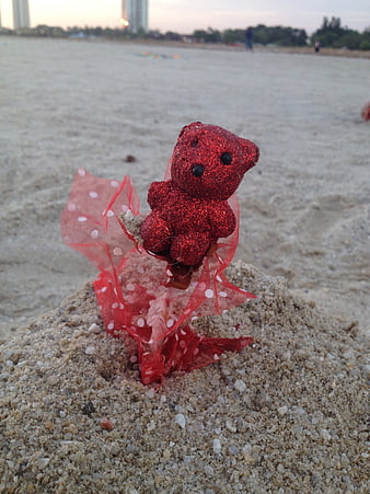 Red Glitter Teddy Bear on Beach Sand