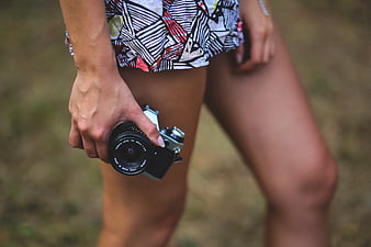 Woman holding vintage camera outdoors
