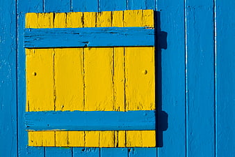 Yellow Wooden Shutter on Blue Wall