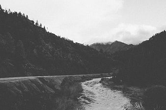 Black and white mountain road alongside a river