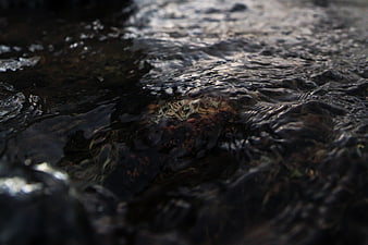 Close-up of dark rippling water flowing over rocks