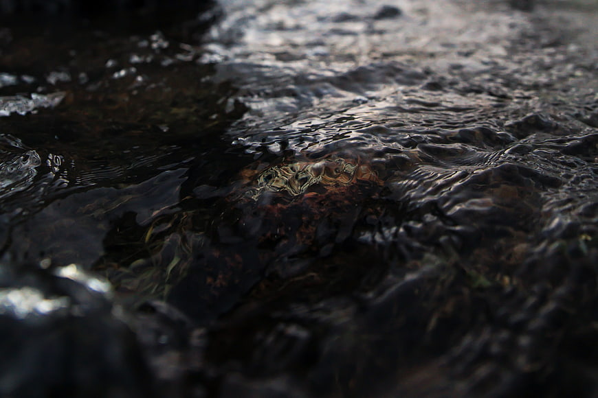 Close-up of dark rippling water flowing over rocks