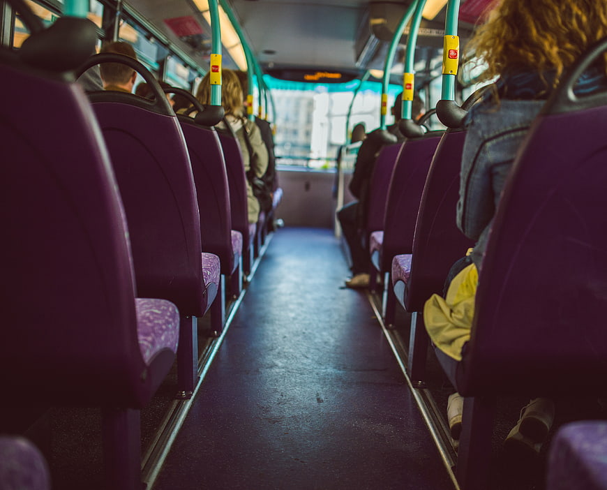 Interior of a city bus with purple seats and passengers