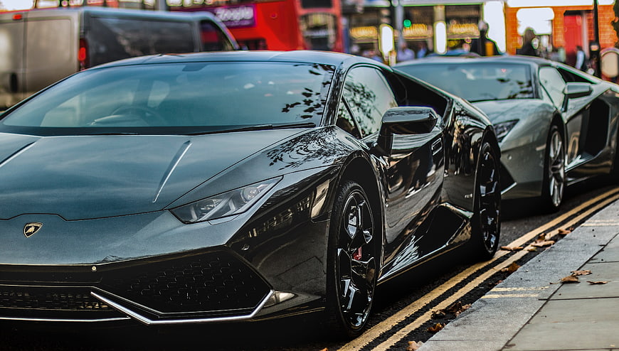 Black Lamborghini Huracan and Silver Aventador Parked on City Street