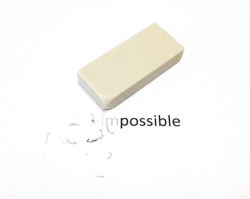 Eraser removing impossible word to reveal possible concept