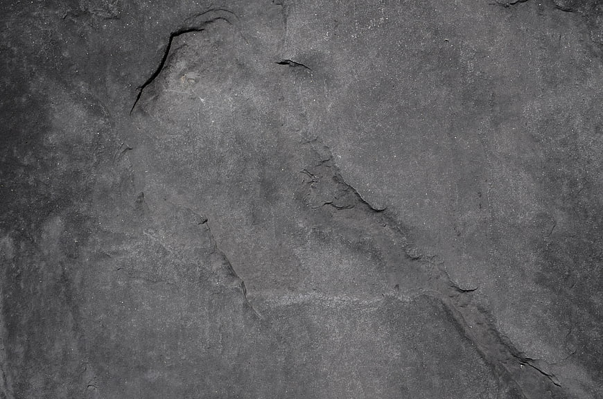 Dark gray rock texture background with cracks