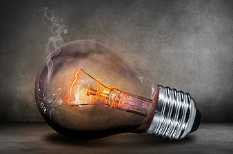 Broken Incandescent Light Bulb with Smoke and Glowing Filament