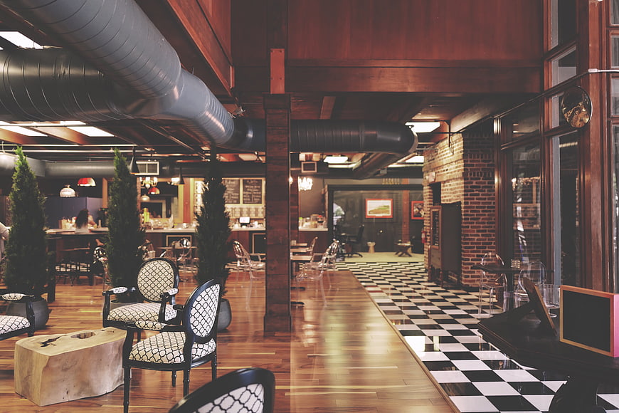 Industrial Chic Restaurant Interior With Exposed Ductwork And Checkered Floor