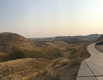 Scenic Badlands Vista with Winding Road and Dry Grass