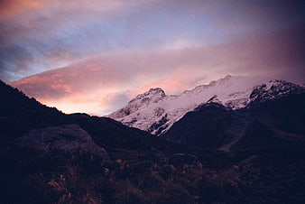 Snow-Capped Mountain Peak at Sunset with Pink Clouds