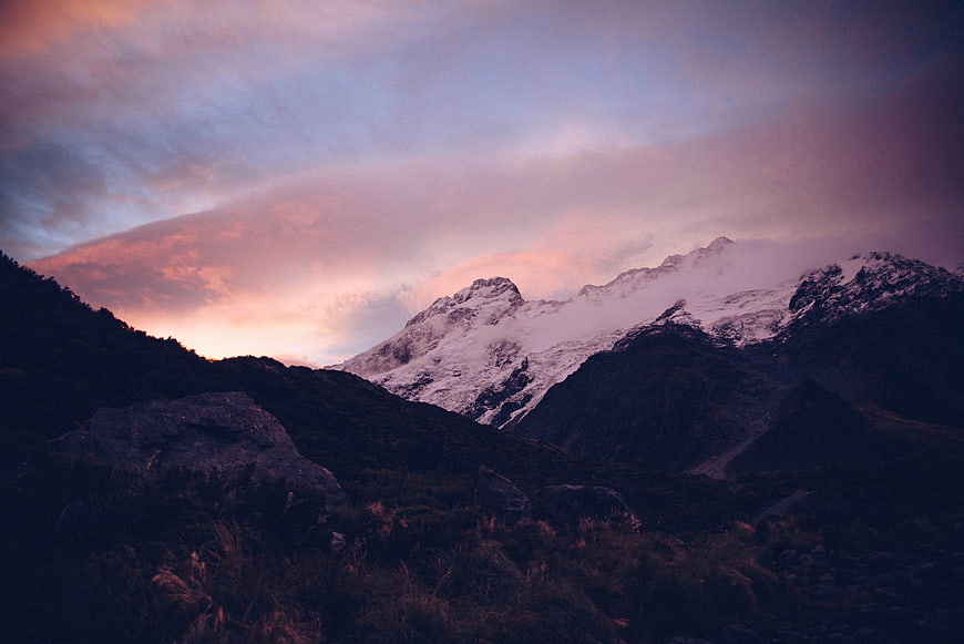 Snow-Capped Mountain Peak at Sunset with Pink Clouds