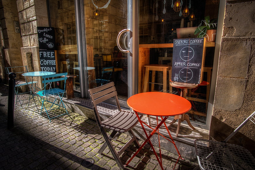 Outdoor cafe seating with orange table and chalkboard sign