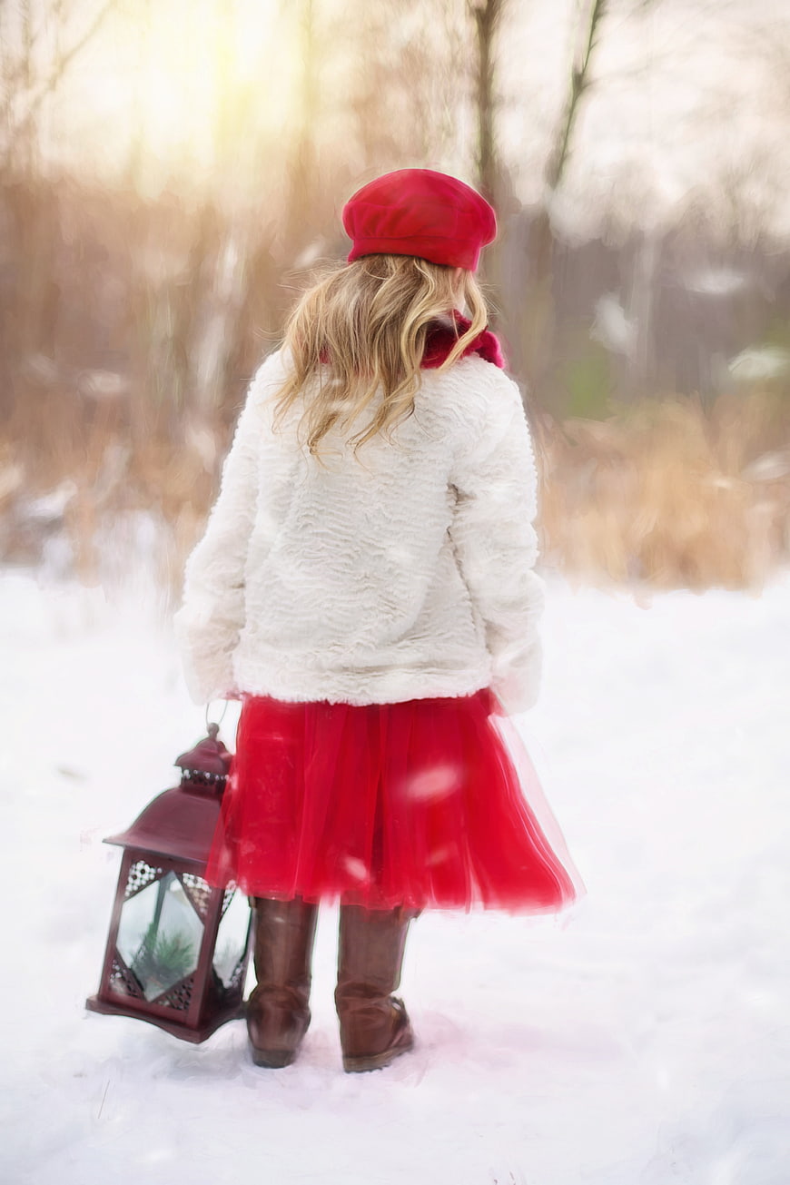Little Girl in Red Skirt and White Coat Holding Lantern in Snow