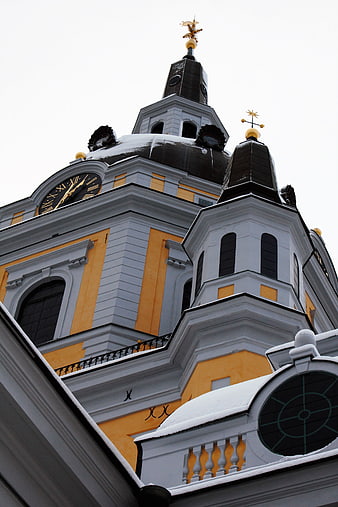 Low angle view of yellow church tower with snow