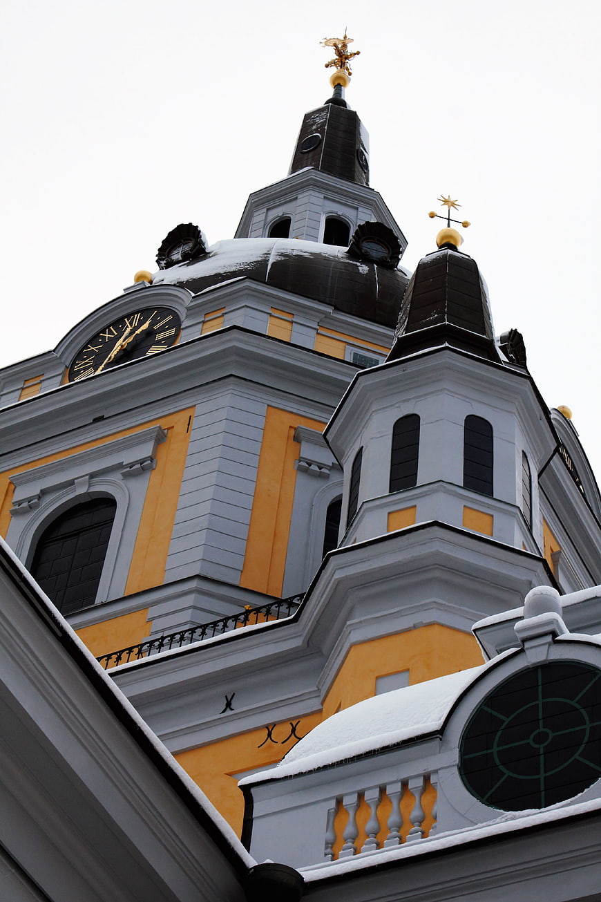 Low angle view of yellow church tower with snow