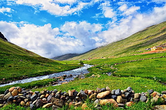 Scenic Mountain Valley with Stream and Green Pastures