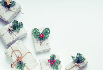 Minimalist Christmas gifts wrapped in white paper with pine branches