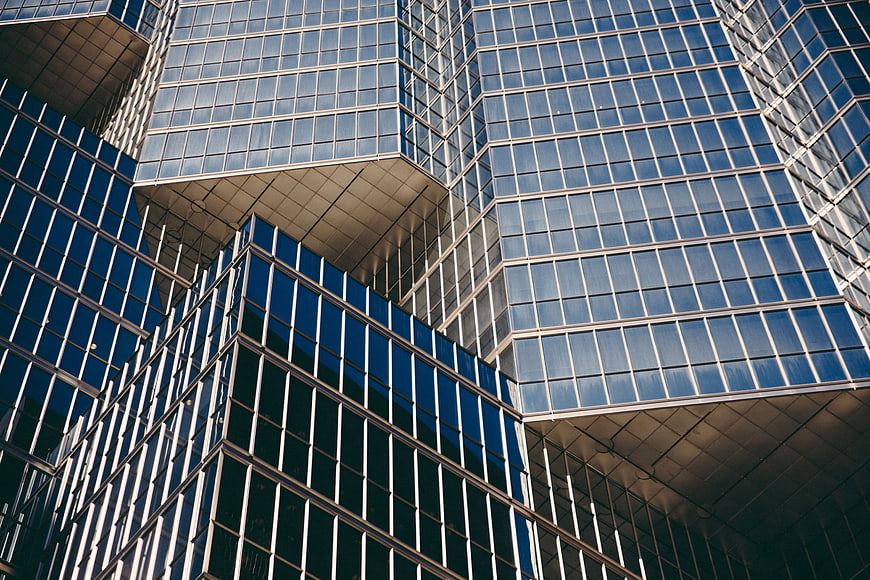 Modern glass skyscraper facade with geometric patterns