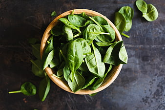 Fresh Spinach Leaves in Wooden Bowl on Dark Background