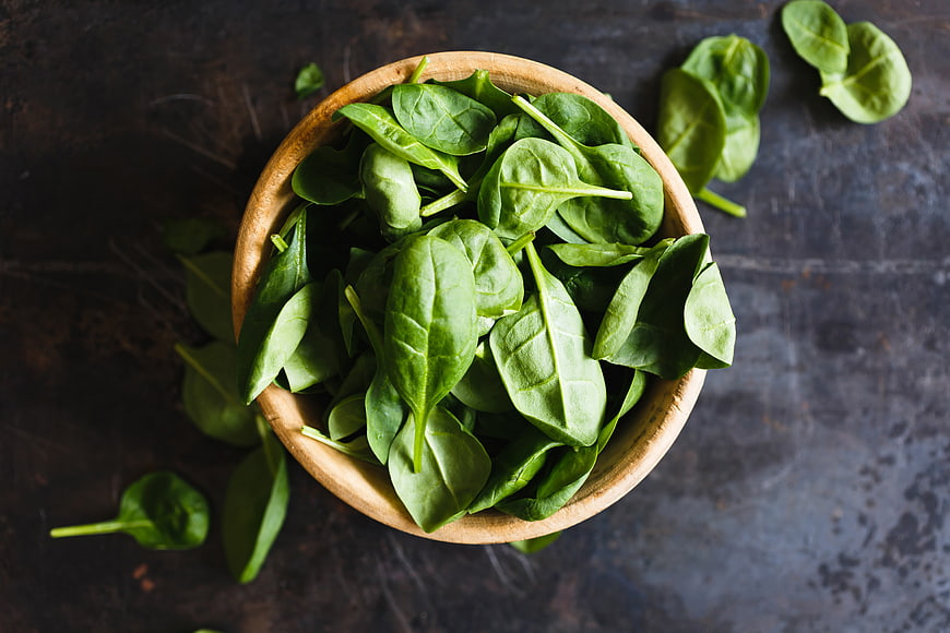 Fresh Spinach Leaves in Wooden Bowl on Dark Background