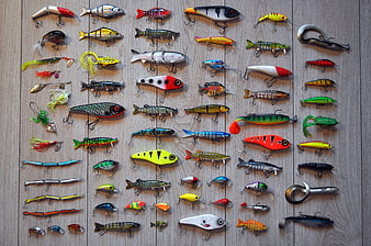 Collection of colorful fishing lures on wooden background