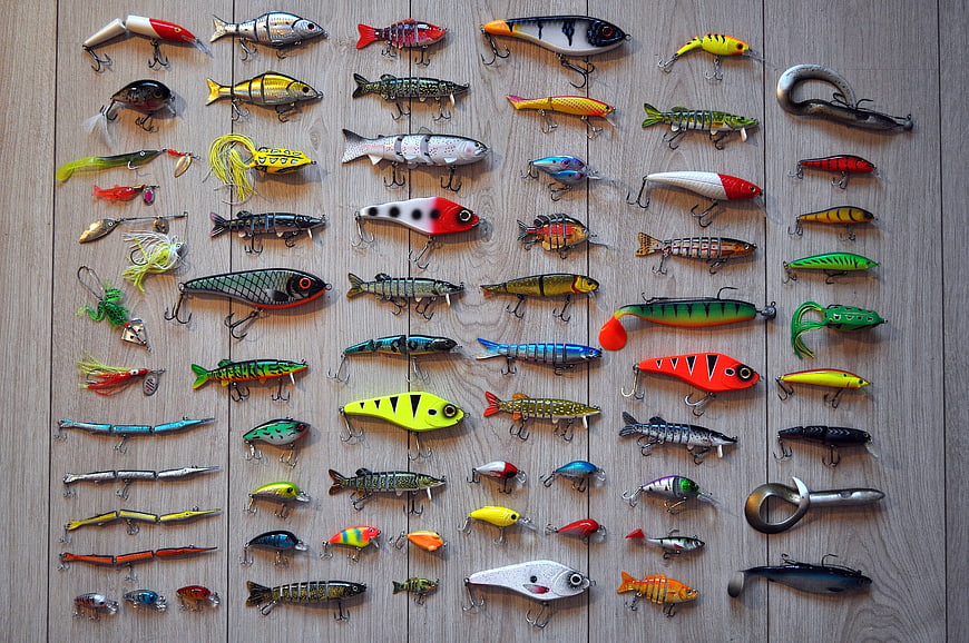 Collection of colorful fishing lures on wooden background