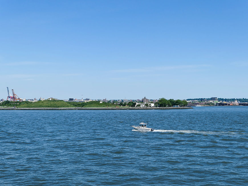 White boat cruising on blue water with city skyline background