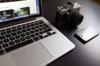 Laptop, Vintage Camera, and Smartphone on Dark Desk