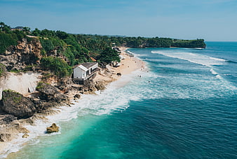 Aerial View of Tropical Beach with Cliffside House and Turquoise Ocean