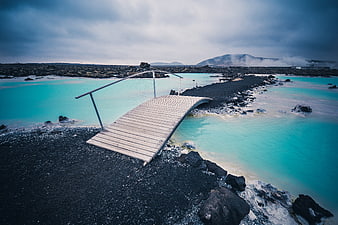 Wooden Bridge Over Turquoise Geothermal Lagoon in Iceland